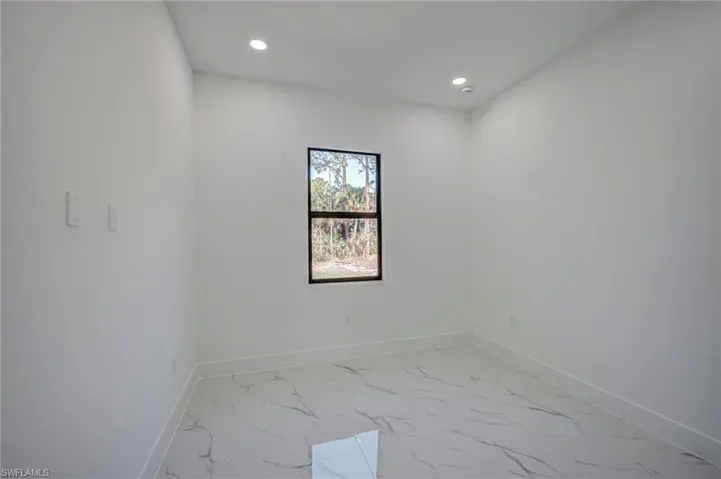 Empty room featuring light marble finish floors and recessed lighting
