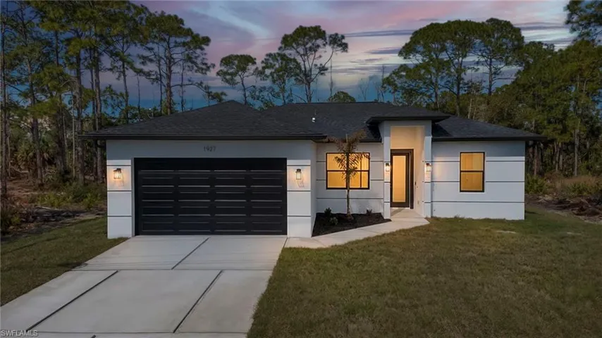 View of front of home featuring a front lawn, concrete driveway, a garage, a shingled roof, and stucco siding