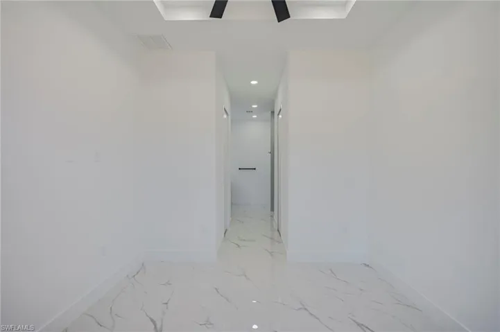 Hallway with recessed lighting and baseboards
