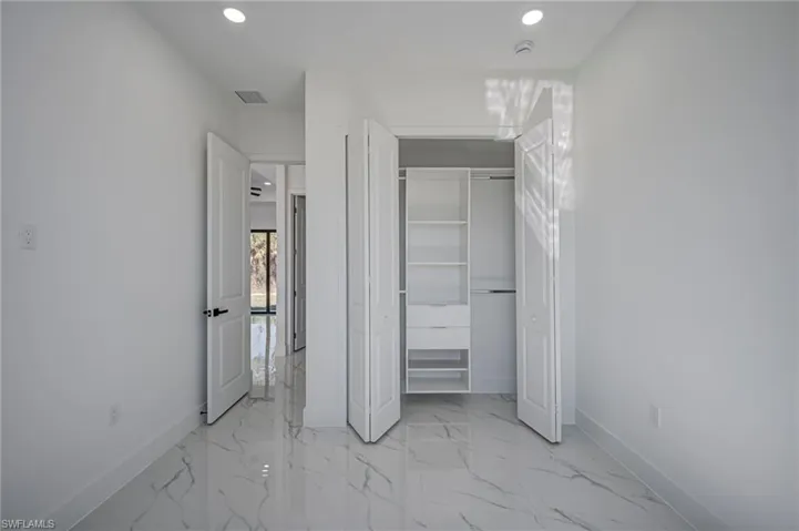 Unfurnished bedroom featuring recessed lighting, a closet, and light marble finish flooring