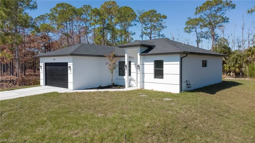 Contemporary single-story residence with a dark shingle roof, white stucco exterior, and black-framed windows