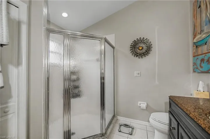 Glass-enclosed shower with textured glass panels and chrome framing