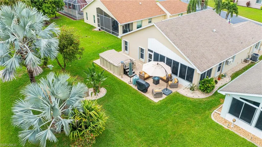 Expansive green lawn with mature palm trees and landscaped rock beds