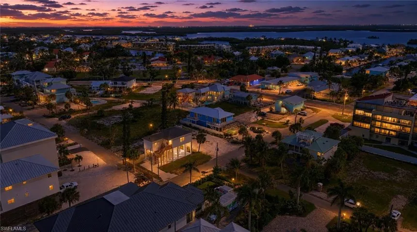 Coastal community featuring residential properties, street lighting, and visible waterways