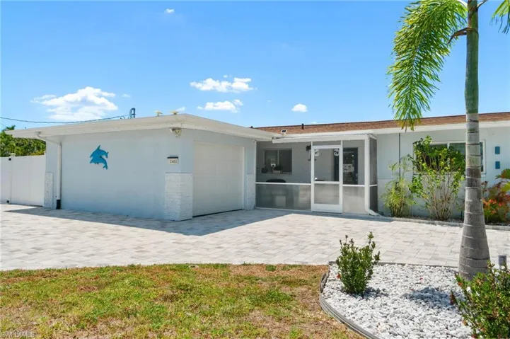 Back of house featuring a patio, a garage, and a sunroom