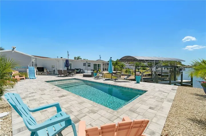 View of swimming pool featuring a patio, an outdoor hangout area, and a boat dock