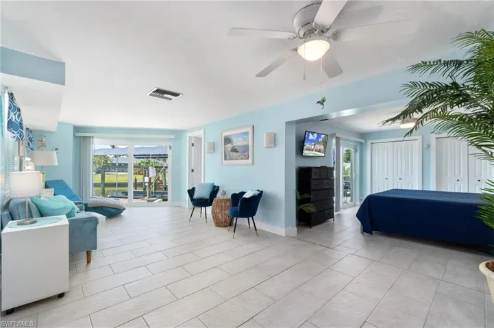 Bedroom featuring ceiling fan, access to outside, and light tile floors