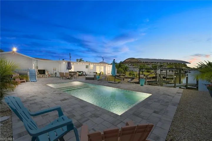 Pool at dusk featuring a patio area