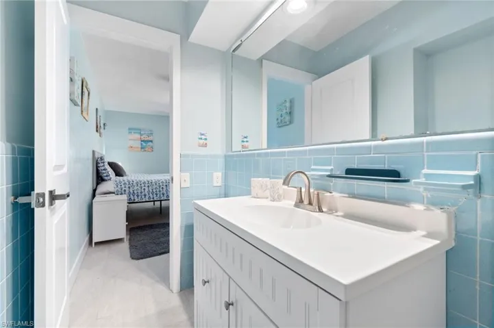 Bathroom with tile walls, tile floors, backsplash, and large vanity