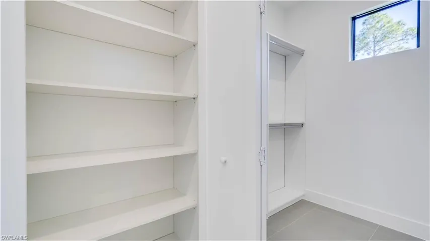 Primary Bath Linen Closet with view of entrance to walk-in double primary closet.