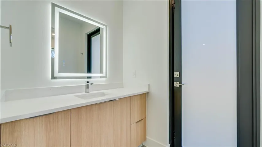 Cabana bathroom with backlit mirror & access to your backyard & future pool!