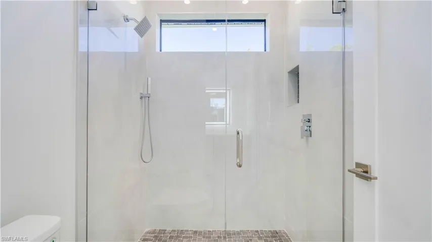 Cabana bathroom tiled walk-in shower with rainfall shower head & hand sprayer.