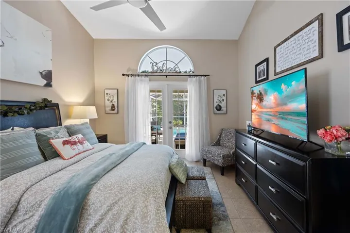 Tiled bedroom with ceiling fan, french doors, and access to exterior