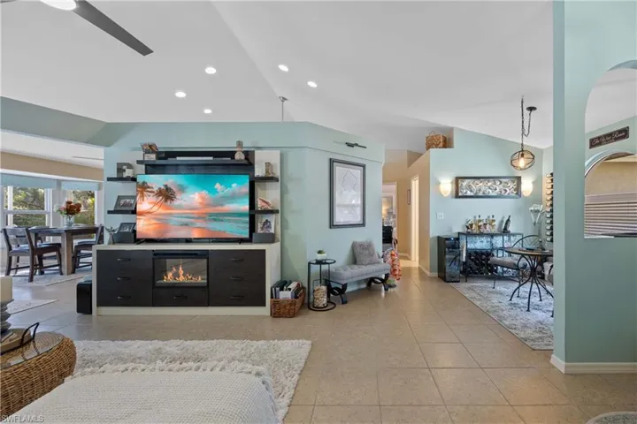 Tiled living room with lofted ceiling and ceiling fan