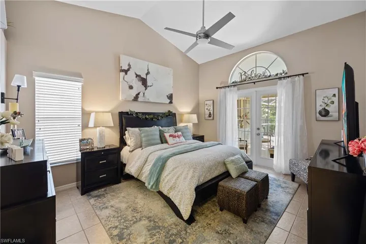 Bedroom with access to outside, vaulted ceiling, french doors, ceiling fan, and light tile patterned floors