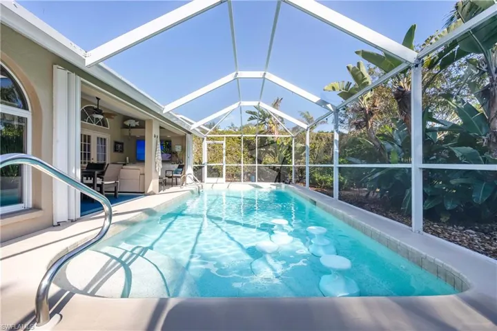 View of swimming pool featuring ceiling fan, a lanai, and a patio area