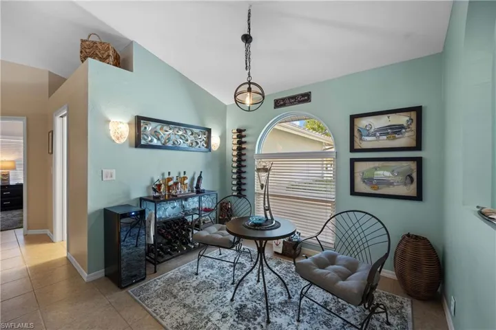 Sitting room with lofted ceiling and light tile patterned floors