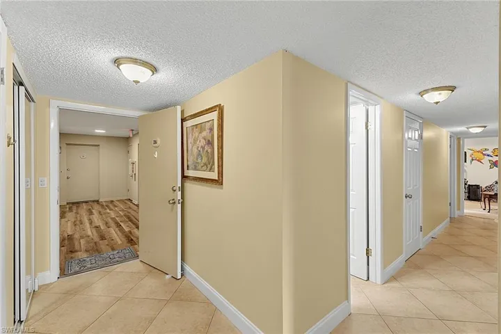 Entry area with neutral painted walls and a textured ceiling
