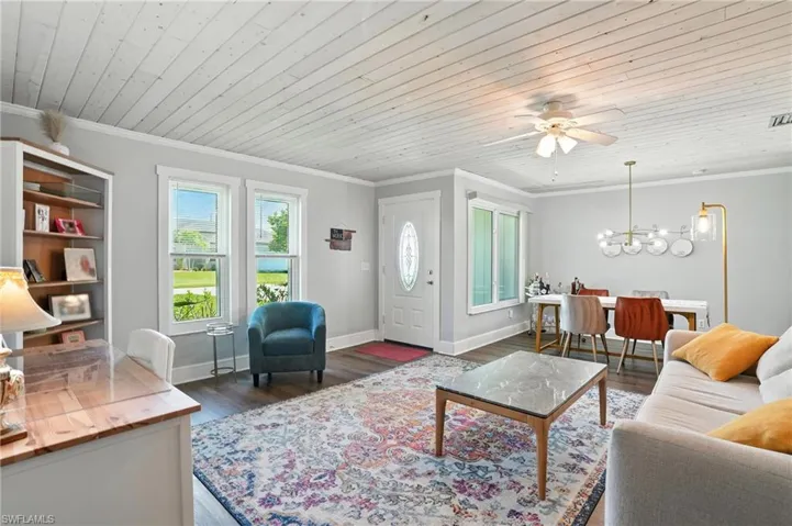Dining room with ornamental molding, wood finished floors, ceiling fan, and wood ceiling