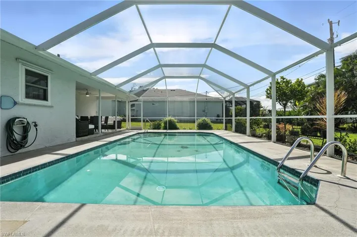 Outdoor pool featuring a patio area, grilling area, and glass enclosure