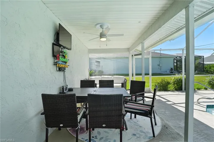 Swimming pool with a patio, an outdoor hangout area, ceiling fan, and a lanai