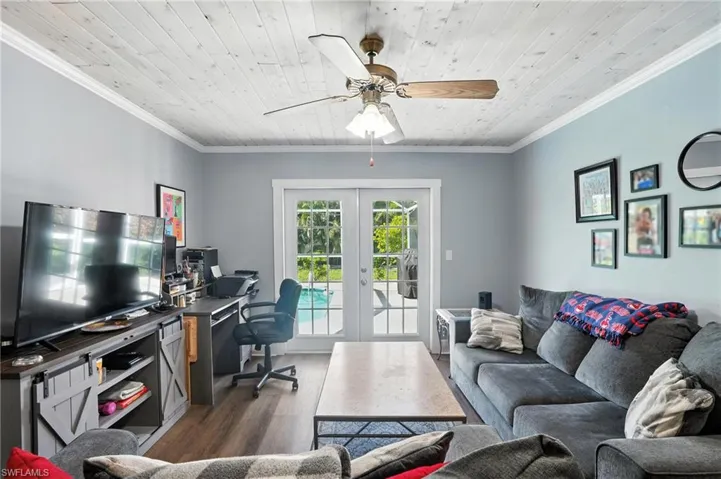 Bedroom featuring crown molding, wooden ceiling, multiple windows, dark wood finished floors, and ceiling fan