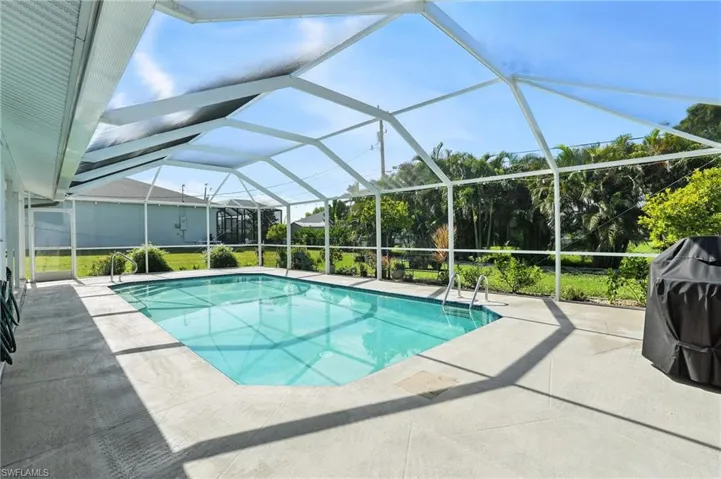 Swimming pool featuring a patio area, area for grilling, and a lanai