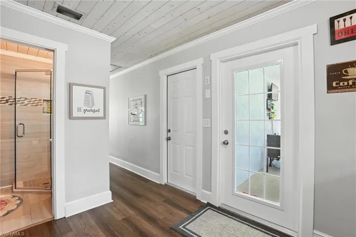Living room with french doors, wood ceiling, light wood-style floors, ceiling fan, and crown molding