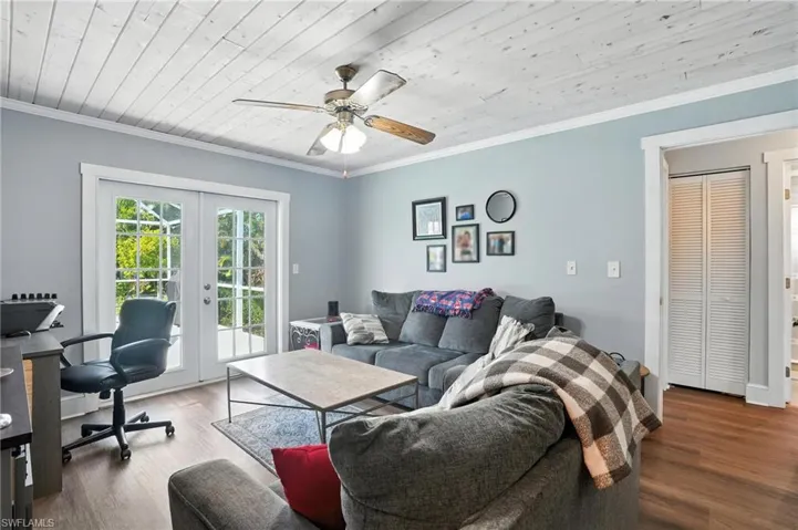 Bedroom featuring wood ceiling, dark wood-style floors, a closet, a ceiling fan, and crown molding