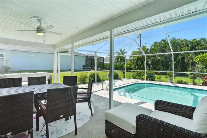 Swimming pool with french doors, a patio area, a grill, and glass enclosure
