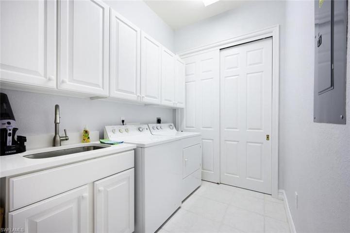 In House Laundry with Tub Sink and Cabinet Storage.