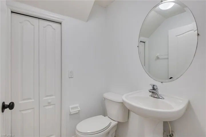 Half bathroom downstairs featuring a closet and toilet