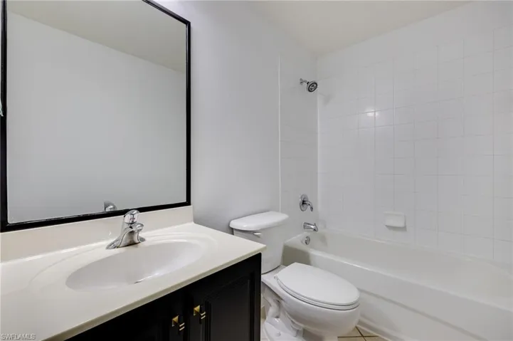 Bathroom featuring vanity, bathing tub / shower combination, and light tile patterned floors