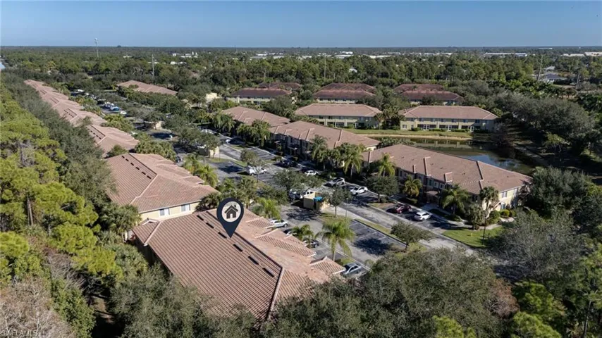 Aerial view of residential area featuring a tree filled landscape and a large body of water