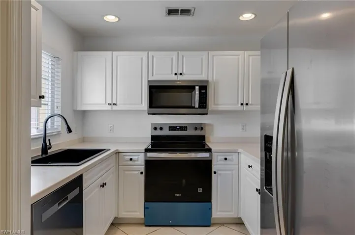 Kitchen featuring appliances with stainless steel finishes, white cabinets, light countertops, and recessed lighting