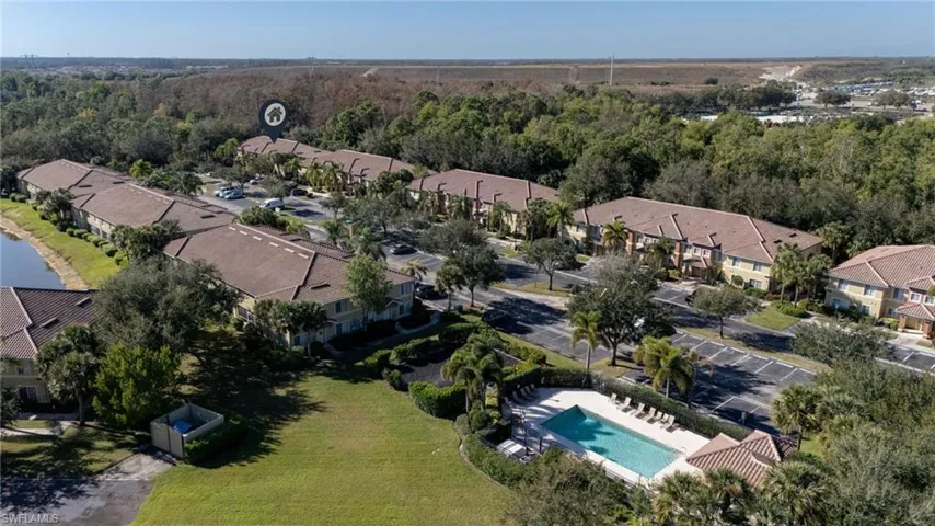 Aerial view of property's location featuring nearby suburban area and a pool area