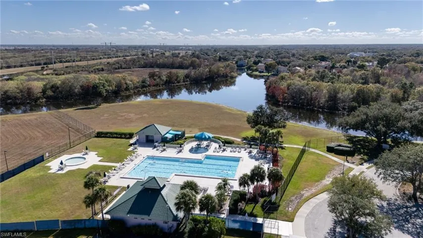Drone / aerial view of a pool and a nearby body of water