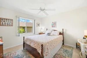 Bedroom with baseboards, tile patterned flooring, and a ceiling fan