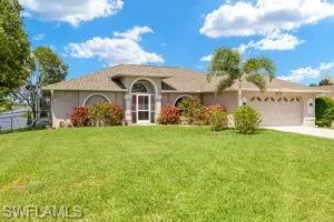 Ranch-style house with concrete driveway, stucco siding, an attached garage, and a front lawn