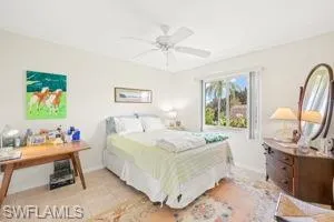 Bedroom featuring baseboards, a ceiling fan, and light tile patterned floors