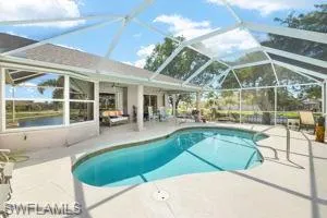 Pool featuring glass enclosure and a patio area