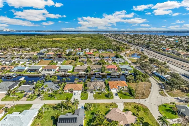 Aerial perspective of suburban area featuring a nearby body of water