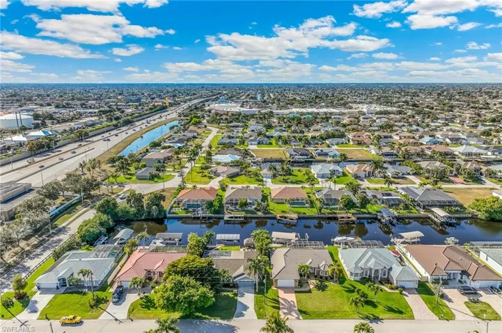 Aerial overview of property's location featuring a nearby body of water and nearby suburban area
