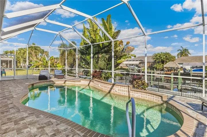 Outdoor pool with a sunroom, a lanai, and a patio area