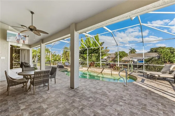 View of patio / terrace featuring a sunroom, outdoor dining space, a lanai, ceiling fan, and an outdoor pool