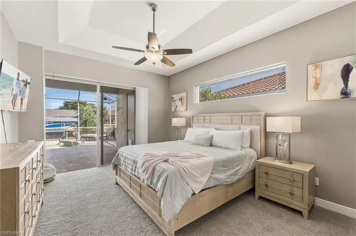 Carpeted bedroom featuring multiple windows, access to outside, and ceiling fan