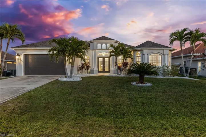 Mediterranean / spanish home featuring french doors, stucco siding, concrete driveway, and a front yard