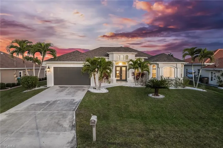 Mediterranean / spanish home with french doors, driveway, stucco siding, a front lawn, and a garage
