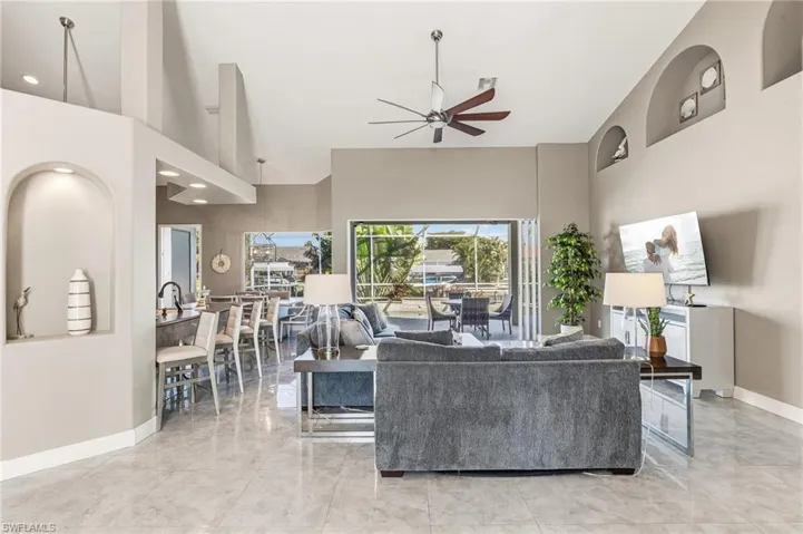 Living room featuring a towering ceiling and ceiling fan
