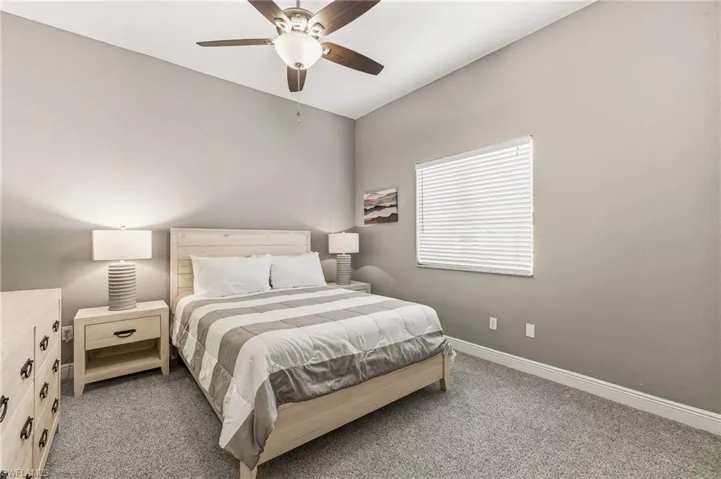 Carpeted bedroom featuring baseboards and a ceiling fan